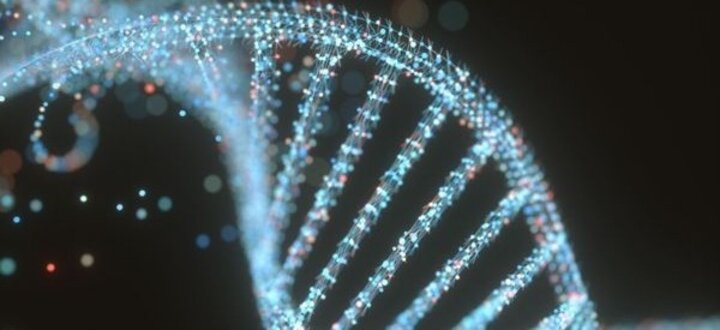 Glowing DNA double helix with dots on a dark background.
